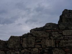 a stone wall with a cloudy sky